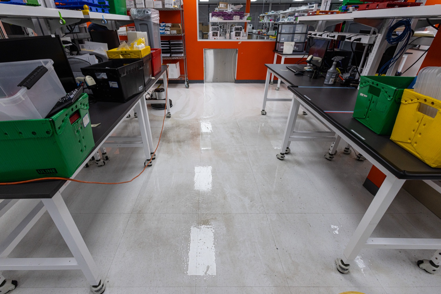 Before: the lab floor mid-strip, wet and dull