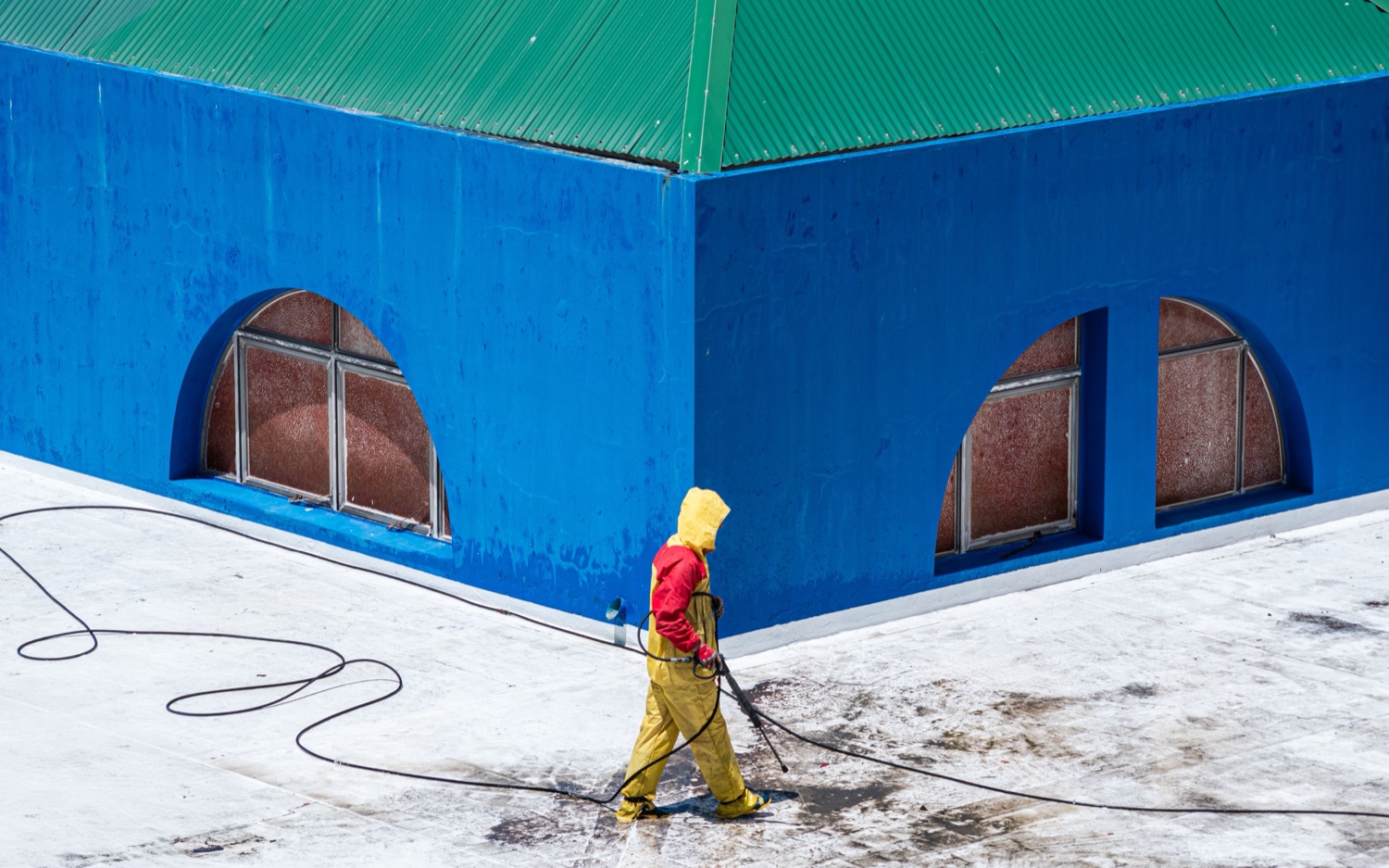 VHH technician pressure washing a commercial building exterior